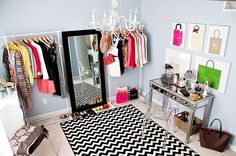 the closet is organized with clothes and handbags on hangers next to a mirror