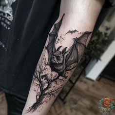 a black and white bat tattoo on the arm