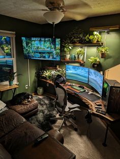 a living room filled with furniture and two monitors