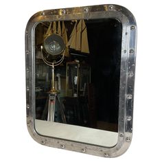 a mirror that is sitting on top of a table in front of a wall mounted light