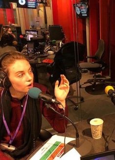 a woman sitting in front of a microphone with headphones on