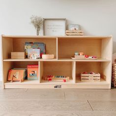 a wooden shelf filled with books on top of a hard wood floor