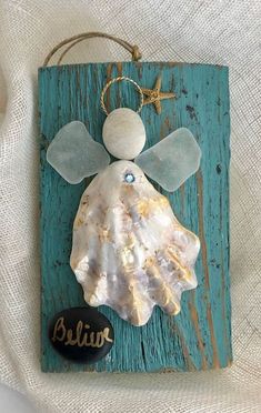 a wooden plaque with a shell and angel on it