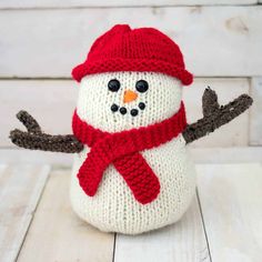 a knitted snowman with a red hat and scarf on it's head