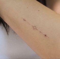 a woman's arm with a small star tattoo on the back of her left arm