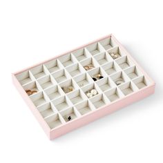 a pink and white box with compartments filled with rings