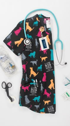 a black shirt with colorful dogs on it next to scissors and other medical supplies, including a stethoscope