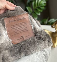 a person holding a fur coat with a leather tag on it