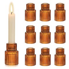 a set of twelve glass candle holders with a lit candle in the middle and six smaller ones on each side