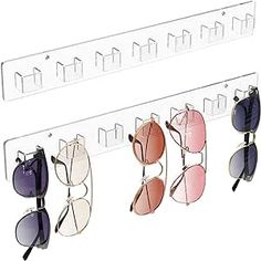 four pairs of sunglasses hanging on a wall with multiple shades in each pair and two different colors