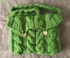 a green knitted purse with buttons on it