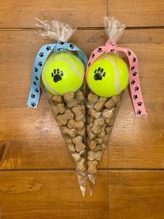 two tennis balls with dog paw heads on them