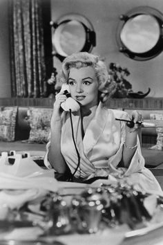 a woman sitting at a table talking on the phone