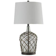 a glass table lamp with a white shade on the base and a black metal frame