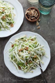 two white plates filled with broccoli and shredded cheese on top of a table