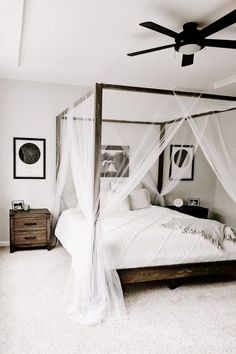 a canopy bed in a bedroom with white walls