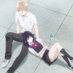 two people sitting on the ground with one person laying down