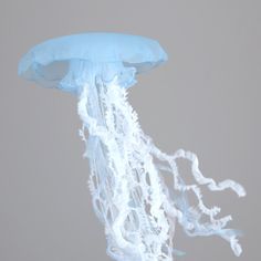 a blue and white jellyfish floating in the air