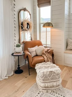 a living room filled with furniture and a mirror on the wall next to a window