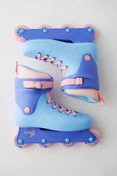 two blue and pink roller skates sitting next to each other on a white surface