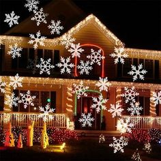 a house covered in christmas lights with snowflakes on the front and side of it