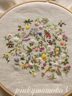 a close up of a embroidery on a piece of cloth with flowers in the middle