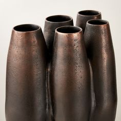 four brown vases sitting on top of each other