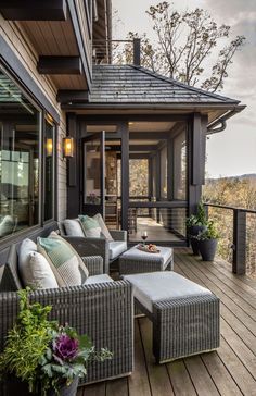 an outdoor patio with wicker furniture and potted plants on the wooden flooring