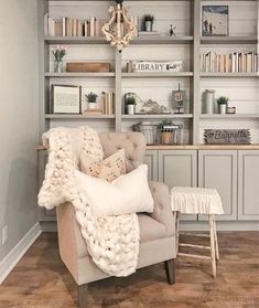 an image of a couch in the middle of a room with bookshelves and shelves