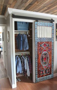 an open closet with clothes on hangers and other items hanging from the door, in a home