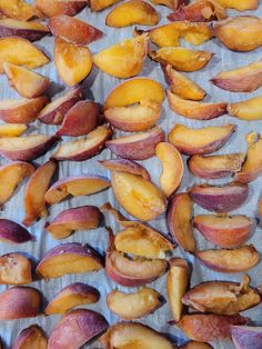 sliced peaches sitting on top of a piece of parchment paper next to each other