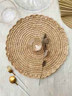 the table is set with gold and white plates, silverware, and straw placemats