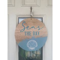 a wooden sign that says seas the day hanging on a white door with an ocean theme