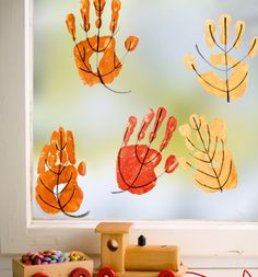 a child's handprint is displayed on a window sill next to toys