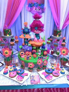 the table is full of cupcakes and cakes for children's birthday party