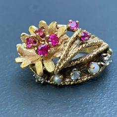 We take pride in finding unique , quality ~ Antique /Vintage jewelry pieces which are carefully hand picked by us so that you can add them to your treasure/ collection or gift to someone you love ~ We try to add plenty of items every week and have been selling online for more then 10 years . Vintage ~ 14kt yellow gold ~ Diamond ~ rubies ~ seed pearl ~ Cocktail /dinner ring ~ There are 6 small prong set faceted rubies , 3 diamonds and two seed pearls with applied wire work ~ Very well made ring . Vintage Multi-stone Cluster Ring For Anniversary, Vintage Multi-stone Ruby Ring In 14k Gold, Vintage 14k Gold Ruby Birthstone Ring, Vintage Gold Multi-stone Cluster Ring, Vintage Gold Pearl Ring With Rose Cut Diamonds, Vintage Gold Cluster Ring With Gemstones, Vintage Gold Multi-stone Ring, Heirloom Multi-stone Pearl Ring For Anniversary, Vintage Multi-stone Gold Ring