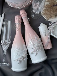 three champagne bottles and two wine glasses on a table