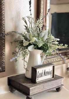 a vase filled with flowers sitting on top of a wooden block next to a mirror