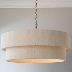 a chandelier hanging from the ceiling in a room with white walls and flooring