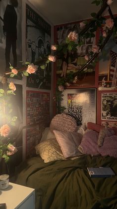 a bedroom with pink flowers and posters on the wall