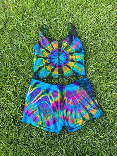 two pieces of colorful tie - dyed clothing laying on the grass