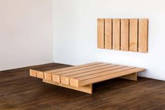 a wooden platform sitting on top of a hard wood floor next to a white wall