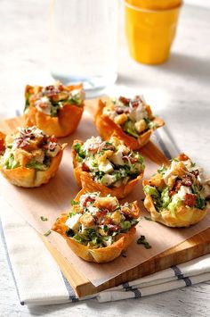 small appetizers are sitting on a cutting board