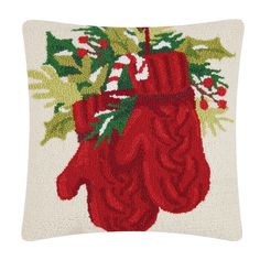 a red christmas mitt hooked up to a white pillow with holly and mist on it