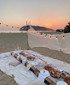 a table set up on the beach with food