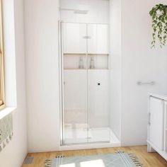 a bathroom with white walls and wooden floors