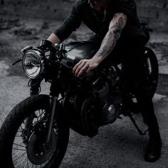 a man sitting on top of a motorcycle in the dark