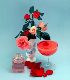 a vase filled with flowers next to a bottle of liquid and hearts on a table