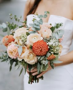 a woman holding a bouquet of flowers in her hands