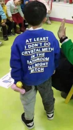 a little boy in a blue jacket standing next to an older man